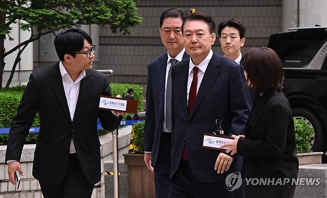 법정 향하는 윤석열 전 대통령 (서울=연합뉴스) 윤석열 전 대통령이 19일 서울 서초구 중앙지방법원에서 열린 내란 우두머리 혐의, 직권남용 권리행사방해 혐의 사건 4차 공판에 출석, 취재진의 질문을 받으며 이동하고 있다. 2025.5.19 [사진공동취재단] photo@yna.co.kr