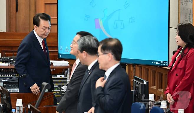 12·3 비상계엄을 선포해 내란 우두머리 혐의로 재판에 넘겨진 윤석열 전 대통령이 지난 4월 21일 오전 서울 서초구 서울중앙지법 417호 법정으로 재판을 받기 위해 들어오자 김계리 변호사(오른쪽) 등 변호인들이 일어나 예를 취하고 있다. 2025.4.21/뉴스1 ⓒ News1 사진공동취재단