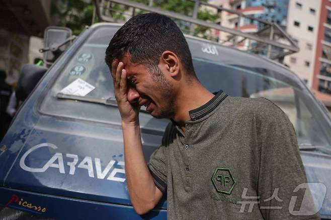 18일(현지시간) 이스라엘 공습 사상자가 이송된 팔레스타인 가자시티의 알시파 병원 밖에서 한 남성이 오열하고 있다.  ⓒ AFP=뉴스1