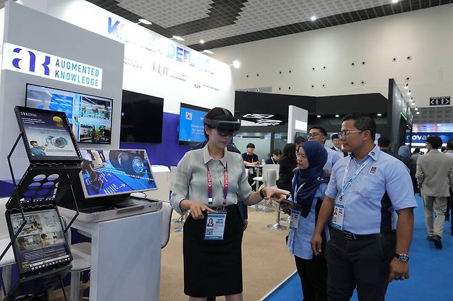 LIMA 2025 통합한국관을 찾은 관람객들이 증강지능 부스에서 AI 기반 디지털 트윈 기술을 체험해보고 있다.(방진회 제공)