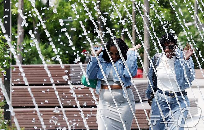 전국 대부분 지역 낮 기온이 25도 이상으로 올라 초여름 날씨를 보인 20일 서울 종로구 광화문광장 분수터널에서 외국인 관광객들이 더위를 식히고 있다. 2025.5.20/뉴스1 ⓒ News1 이동해 기자