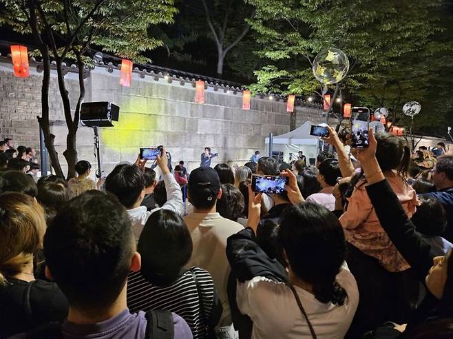 지난해 정동야행 축제에 참여한 시민들이 덕수궁 돌담길 앞 무대에서 펼쳐지는 거리공연을 감상하고 있다. 중구 제공.