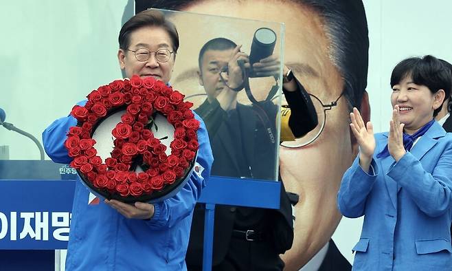이재명 더불어민주당 대통령 후보가 20일 오후 경기도 고양시 일산문화공원에서 유세 시작에 앞서 장미로 만든 기표 용구 모양의 꽃다발을 선물받고 있다. 공동취재사진