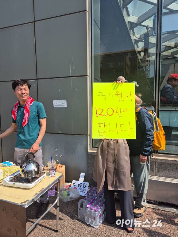 20일 서울 서초구 고속터미널역 앞에서 열린 김문수 국민의힘 대선 후보 현장 유세에서 한 시민이 이재명 후보의 '커피 원가 120원' 발언을 겨냥해 믹스커피를 판매하고 있다. [사진=유범열 기자]