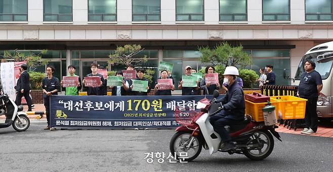 기자회견 장 앞으로 배달노동자가 지나가고 있다.