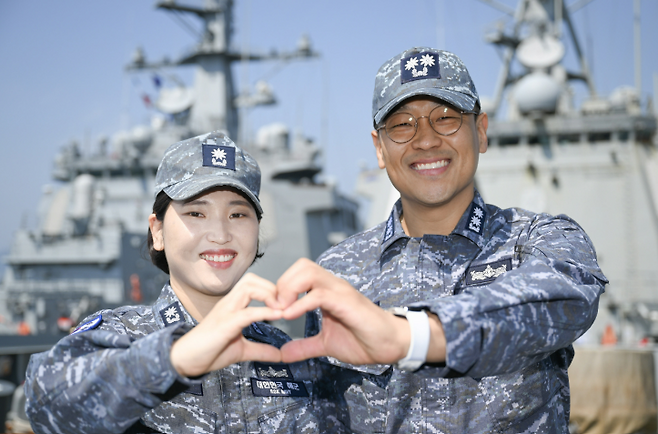 율곡이이함 기관장 임재우 중령(진)과 정조대왕함 주기실장 김보아 소령이 율곡이이함 함수갑판에서 '손하트'로 인사하고 있다. 해군 제공