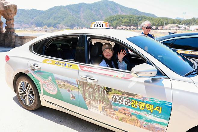 울진 관광택시에 탄 관광객이 손을 흔들고 있다. 울진군 제공