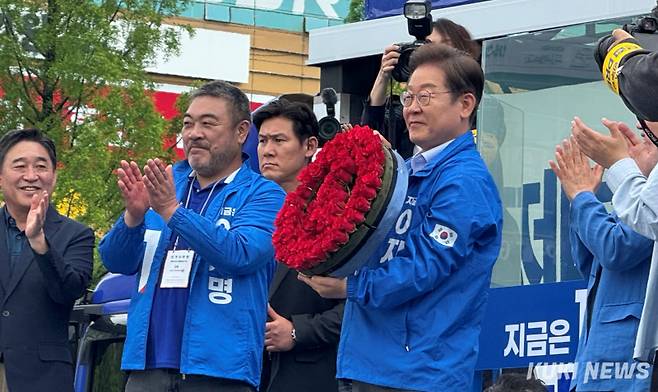 이재명 더불어민주당 대선 후보(오른쪽)가 20일 경기 고양시 일산호수공원에서 장미로 만든 투표마크 장식품을 들어보이고 있다. 왼쪽은 배우 이원종. 송금종 기자&nbsp;
