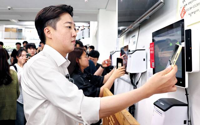 이준석 개혁신당 대선 후보가 20일 ‘학식먹자 이준석, 전남대로 갑니다’ 일정 수행을 위해 광주 북구 전남대 학생식당을 방문해 휴대전화로 식권을 구입하고 있다. 연합뉴스