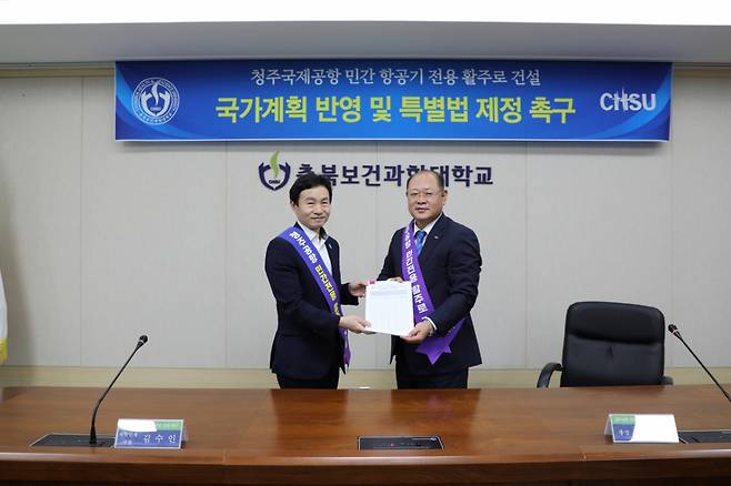 박용석 충북보건과학대 총장이 김수인 충북도 과학인재국장에게 서명록을 전달하고 있다./사진제공=충북보건과학대