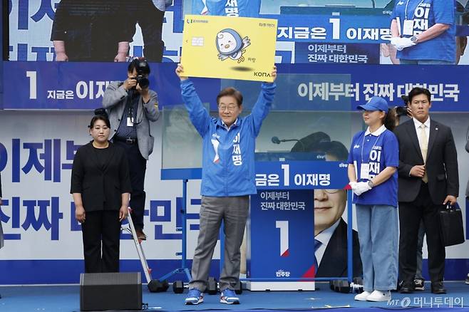 (파주=뉴스1) 안은나 기자 = 이재명 더불어민주당 대통령 후보가 수도권 표심잡기에 나선 20일 오후 경기 파주시 금릉역 중앙광장에서 열린 유세에서 경기지역화폐 파주페이 카드 판넬을 들어보이고 있다.  2025.5.20/뉴스1  Copyright (C) 뉴스1. All rights reserved. 무단 전재 및 재배포,  AI학습 이용 금지. /사진=(파주=뉴스1) 안은나 기자