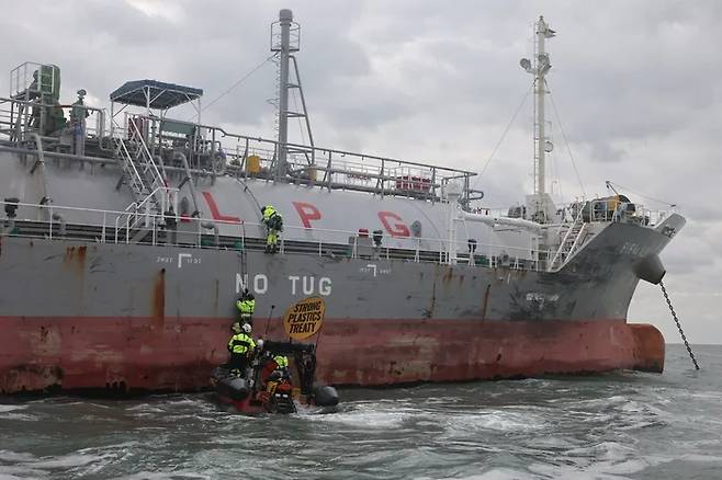 그린피스 인터내셔널 소속 활동가 4명이 지난해 11월 30일 부산에서 열린 유엔 국제 플라스틱 협약 제5차간 정부간 협상회의(INC5)를 앞두고 충남 서산 대산석유화학단지 인근 해상 LPG 운반선을 오르고 있다.[그린피스 제공]