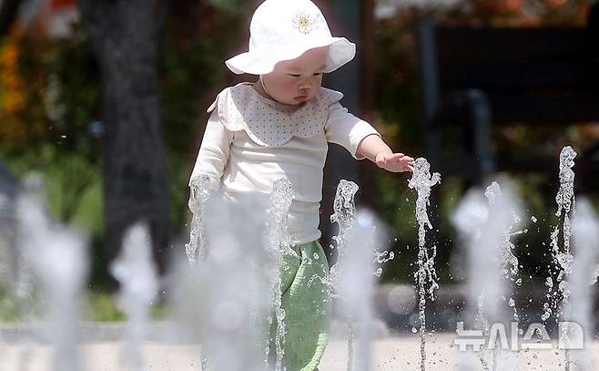 [대구=뉴시스] 이무열 기자 = 대구 낮 최고기온이 33도까지 오르며 무더운 날씨를 보인 20일 대구 서구 평리공원 바닥분수에서 아기가 물놀이를 하고 있다. 2025.05.20. lmy@newsis.com