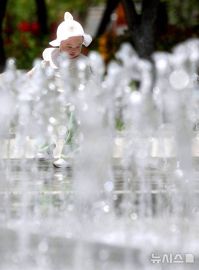 [대구=뉴시스] 이무열 기자 = 대구 낮 최고기온이 33도까지 오르며 무더운 날씨를 보인 20일 대구 서구 평리공원 바닥분수에서 아기가 물놀이를 하고 있다. 2025.05.20. lmy@newsis.com