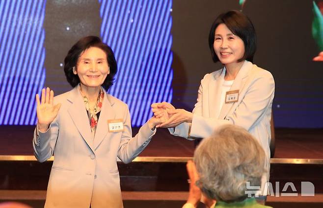 [서울=뉴시스] 조성봉 기자 = 이재명 더불어민주당 대선 후보의 부인 김혜경 여사와 김문수 국민의힘 대선후보의 부인 설난영(왼쪽) 여사가 지난 12일 서울 중구 신라호텔에서 열린 중앙신도회 창립 70주년 기념식에서 손을 맞잡고 있다. (사진=조계종 제공) 2025.05.13. photo@newsis.com