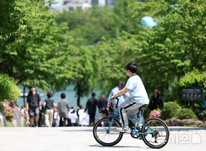 [서울=뉴시스] 김진아 기자 = 서울 낮기온이 26도로 초여름 더위를 보인 30일 서울 송파구 석촌호수에서 한 어린이가 자전거를 타고 있다. 2025.04.30. bluesoda@newsis.com