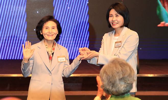 이재명 더불어민주당 대선 후보의 부인 김혜경 여사와 김문수 국민의힘 대선후보의 부인 설난영(왼쪽) 여사가 12일 서울 중구 신라호텔에서 열린 중앙신도회 창립 70주년 기념식에서 손을 맞잡고 있다. 조계종 제공