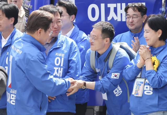이재명 더불어민주당 대선 후보가 19일 서울 용산역 광장에서 진행된 집중유세에서 국민의힘을 탈당하고 민주당에 입당한 김상욱 의원과 인사하고 있다. 오승현 기자 2025.05.19
