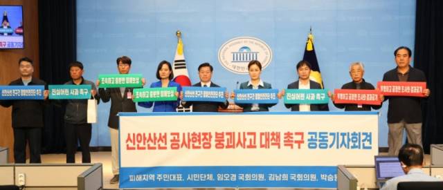 20일 오전 국회에서 열린 신안산선 붕괴사고 대책 마련을 촉구하는 기자회견에서 (왼쪽부터)허정호 광명경실련 사무처장, 김동철 구석말 건물주 대표 , 이태현 피해주민 대표, 김남희 국회의원, 박승원 광명시장, 임오경 국회의원, 이병식 구석말 상가부위원장, 김광응 양지마을 자치회장, 김진곤 피해주민 대표가 피켓을 들고 있다. 사진 제공=광명시