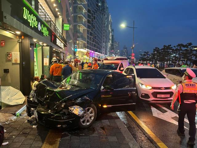21일 오후 7시 22분께 부산 수영구 광안리해수욕장 뒷편 도로를 달리던 한 승용차가 신호 대기 중이던 차량을 들이받고 인도로 돌진하는 사고가 발생했다. 부산소방재난본부 제공