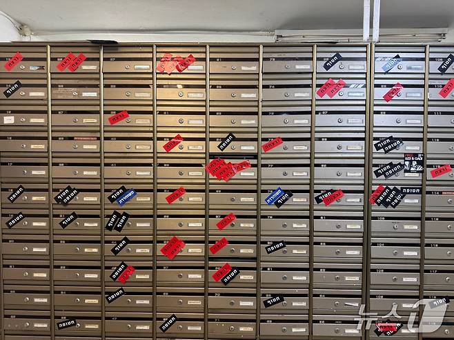 이스라엘 남부 키부츠 니르오즈의 우편함. 10월7일 이후 17일이 지난 시점 기준이다. 검은색은 하마스에 납치돼 가자지구에 억류된 사람, 빨간색은 사망한 사람, 파란색은 납치됐다가 풀려난 사람을 표시한다.