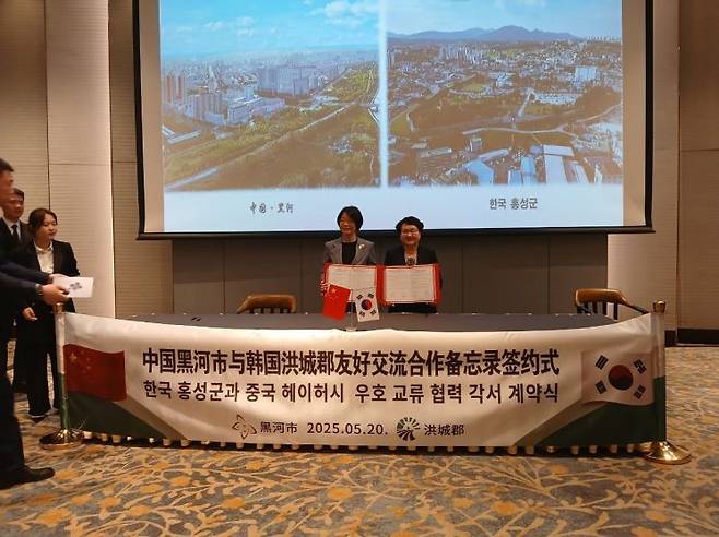 조광희 홍성 부군수가 중국 헤이허시 부시장과 우호교류 협력 각서에 서명 교환하고 있다./홍성군 제공