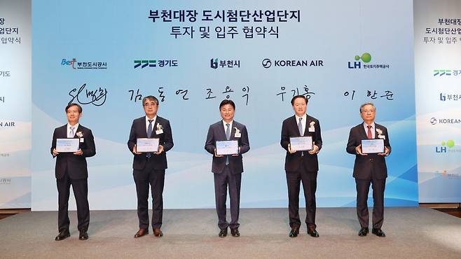 조용익 부천시장(가운데)이 지난달 30일 부천아트센터에서 대한항공, 경기도,한국토지주택공사 관계자 등이 참석한 가운데 열린 ‘부천 대장 도시첨단산업단지 투자 및 입주 협약식’에서 환하게 웃고 있다. 부천시 제공