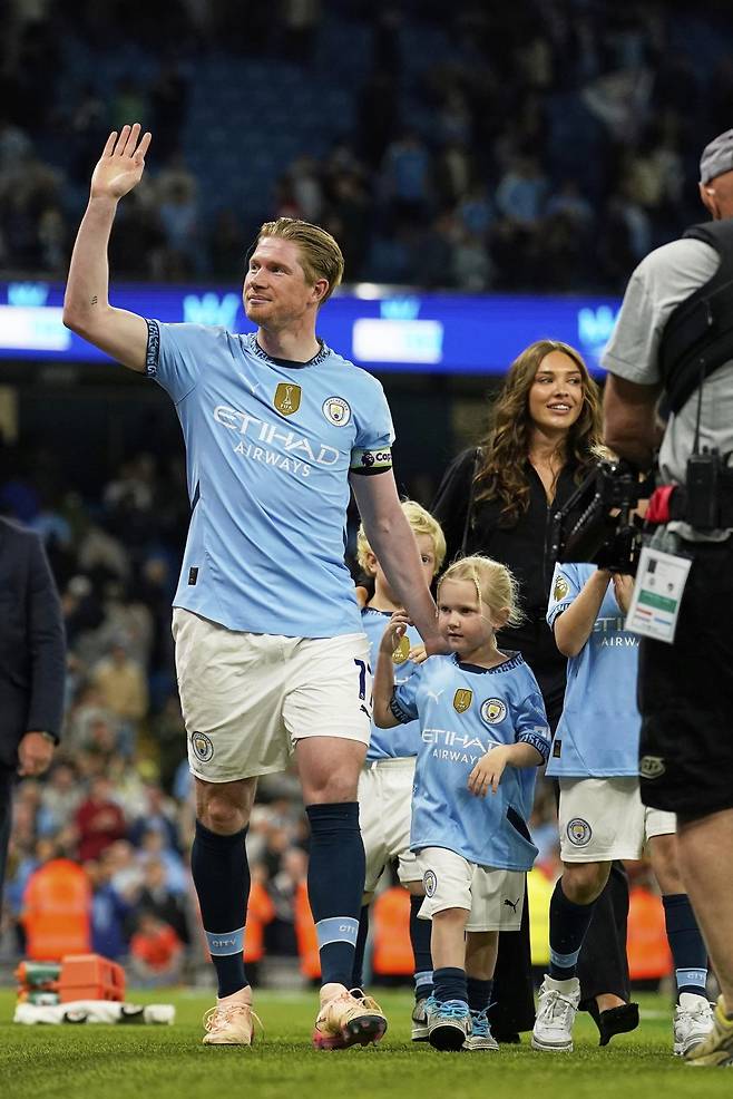 올 시즌을 끝으로 10년간 몸담았던 잉글랜드 프리미어리그(EPL) 맨체스터시티를 떠나는 케빈 더브라위너(왼쪽)가 가족들과 함께 맨시티 안방 구장인 에티하드 스타디움에서 팬들에게 인사를 하고 있다. 맨체스터=AP 뉴시스