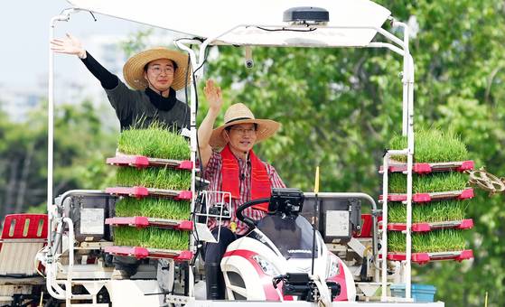 김문수 국민의힘 대선후보가 21일 오후 경기 고양시 덕양구 화정동 일대 논에서 청년농업인과 이앙기에 탑승해 모내기를 하며 손을 흔들고 있다. 임현동 기자