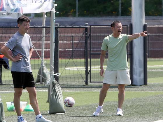 SON Football Academy director Song Woong-jung, right, and head coach Son Heung-yun instruct youth players at the Son Heung-min Sports Park in Chuncheon, Gangwon on June 8, 2022. [YONHAP]