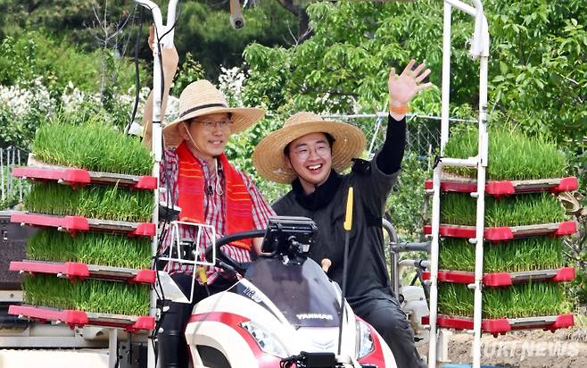 김문수 국민의힘 대통령 후보가 21일 경기 고양시 한 논에서 청년 농업인과 모내기 이앙 작업을 하며 밝은 표정으로 지지자들을 향해 손을 흔들 있다.