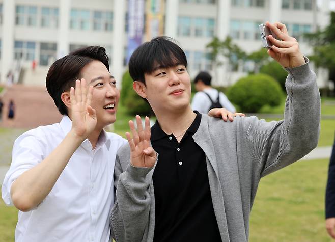 개혁신당 이준석 대선 후보가 20일 광주 북구 전남대학교 학생회관 앞에서 한 학생과 사진을 찍고 있다. [사진 출처 = 연합뉴스]