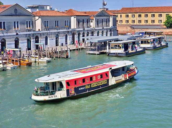 농심이 세계적인 관광지 이탈리아 베네치아의 수상버스(Vaporetto)에 ‘신라면’ 래핑 광고를 다음 달 10일까지 선보인다. ‘신라면’으로 꾸며진 수상버스가 베네치아 운하에 떠 있는 모습. <농심>