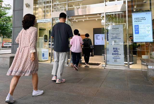 유심 교체, 여전한 대기줄 대규모 해킹 사고가 발생한 SK텔레콤 고객들이 유심칩을 교체하기 위해 21일 서울 중구에 있는 한 SK텔레콤 대리점에 들어서고 있다. 윤성호 기자