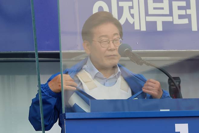 이재명 더불어민주당  대선 후보가 21일 자신의 지역구인 인천광역시 계양역 앞 유세에서 방탄유리, 방탄조끼 비판에 대해 항변하던 중 점퍼 속 방탄조끼를 보여주고 있다. [연합]