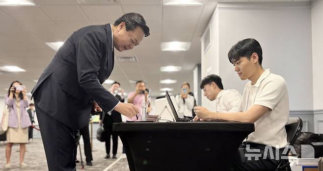 [워싱턴=뉴시스]이윤희 특파원 = 20일(현지 시간) 미국 버지니아주 알렉산드리아 코리안커뮤니티센터에 마련된 제21대 대통령선거 재외투표 투표소에서 조현동 주미대사가 본인 확인을 하고 있다. 이번 대선 재외선거는 이날부터 오는 25일까지 전 세계 118개국 223개 투표소에서 진행된다. 2025.05.21. sympathy@newsis.com