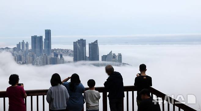 [부산=뉴시스] 하경민 기자 = 초여름 더위가 이어진 21일 부산 황령산의 한 전망대를 찾은 관광객들이 짙은 해무로 뒤덮인 도심을 구경하고 있다. 2025.05.21. yulnetphoto@newsis.com