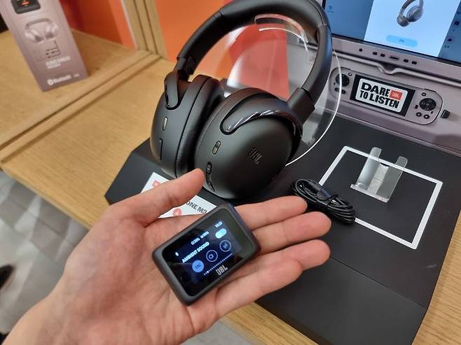 [서울=뉴시스] 이지용 기자 = 하만 오디오 브랜드 JBL의 고성능 헤드폰인 'JBL 투어 원 M3 스마트 Tx'와 무선 오디오 송신기인 'JBL 스마트 Tx'. 송신기는 손 안에 쉽게 들어올 만큼 작은 크기와 무게를 가졌다. 헤드폰을 통해 비행기 좌석 모니터의 콘텐츠들을 시청할 수 있다. 2025.05.21. leejy5223@newsis.com *재판매 및 DB 금지