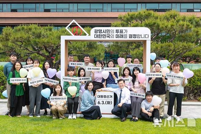 [광명=뉴시스]박승원 광명시장이 21일 점심시간 직원들과 시청 잔디광장에 설치된 투표 참여 조형물에서 캠페인을 진행하며 기념사진을 촬영하고 있다.(사진=광명시 제공)2025.05.21.photo@newsis.com