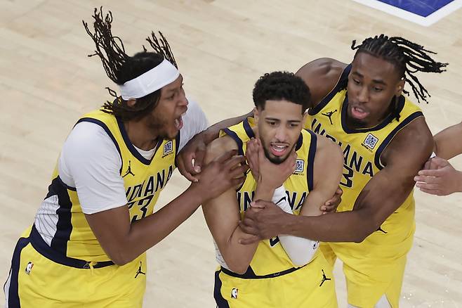 <yonhap photo-4677=""> Indiana Pacers guard Tyrese Haliburton (0) is mobbed by teammates as he makes a choking motion after hitting a shot against the New York Knicks at the end of regulation to tie Game 1 of the NBA basketball Eastern Conference final, Wednesday, May 21, 2025, in New York. (AP Photo/Adam Hunger)/2025-05-22 12:14:00/ <저작권자 ⓒ 1980-2025 ㈜연합뉴스. 무단 전재 재배포 금지, AI 학습 및 활용 금지></yonhap>