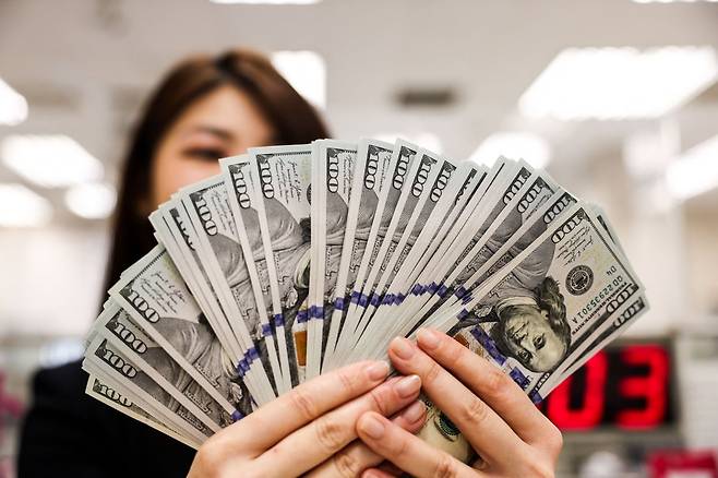 타이베이에서 한 은행 직원이 미화 100달러 지폐를 들어 보이고 있다. / 사진=AFP