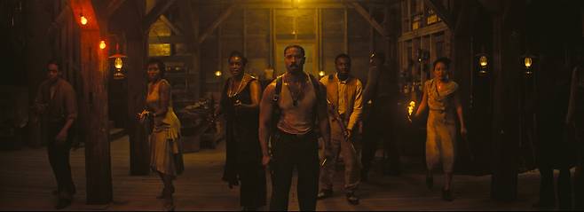 영화 <씨너스: 죄인들> 한 장면. 주점 ‘주크 조인트’의 인물들이 경계하며 한 곳을 바라보고 있다. 워너브라더스코리아 제공