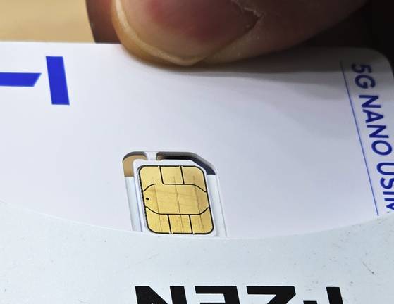 An employee at an SK Telecom retail store in Seoul demonstrates how to reset a SIM card on May 12. [YONHAP]