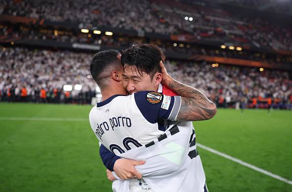 태극기를 몸에 두른 손흥민이 22일(한국시간) 스페인 빌바오의 산 마메스 경기장에서 열린 2024-2025 유럽축구연맹(UEFA) 유로파리그(UEL) 결승전에서 정상에 오른 뒤 페드로 포로를 끌어 안고 우승의 기쁨을 나누고 있다.    [로이터]