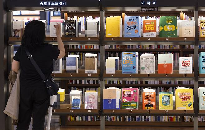 지난달 22일 서울 종로구 교보문고 광화문점을 찾은 시민이 베스트셀러를 고르고 있다. [연합뉴스]