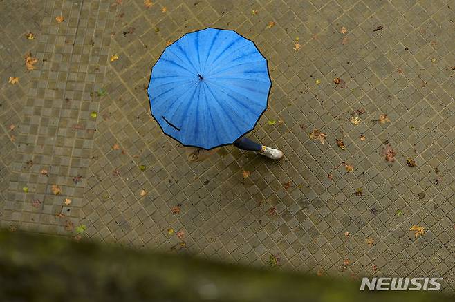 [팜플로나=AP/뉴시스]목요일인 22일은 수도권을 포함한 전국에 곳곳에 비가 내리겠다. 수도권 강수는 오전 중 그치겠다. 사진은 2023년 9월 2일(현지시간) 스페인 북부 팜플로나에 비가 내리자 한 여성이 우산을 쓰고 이동하는 모습. 2025.05.21.