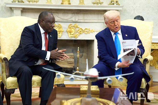 [워싱턴=AP/뉴시스] 도널드 트럼프(오른쪽) 미국 대통령이 21일(현지 시간) 백악관 집무실에서 시릴 라마포사 남아공 대통령과 회담하면서 자료를 공개하고 있다. 트럼프 대통령은 회담 중 남아공의 '백인 농부 집단 살해' 의혹을 공개적으로 제기, 해명을 요구하면서 정상 간 공방이 이어졌다. 2025.05.22.