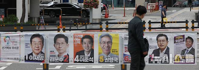 [서울=뉴시스] 조수정 기자 =  21대 대통령선거일을 15일 앞둔 19일 서울 중구 퇴계로에서 시민들이 선거 벽보를 보며 걸어가고 있다. 2025.05.19. chocrystal@newsis.com