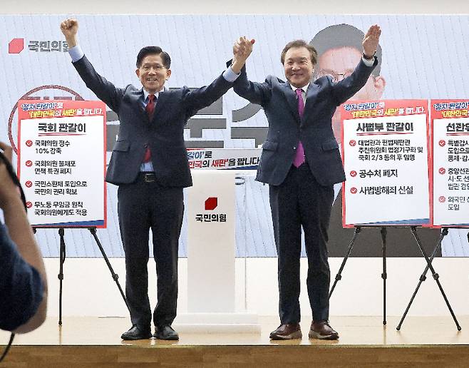 국민의힘 김문수 대선 후보와 손학규 전 민주당·바른미래당 대표가 22일 서울 여의도 국민의힘 중앙당사에서 열린 정치개혁 관련 긴급 기자회견에서 함께 손을 들어보이고 있다. 연합뉴스