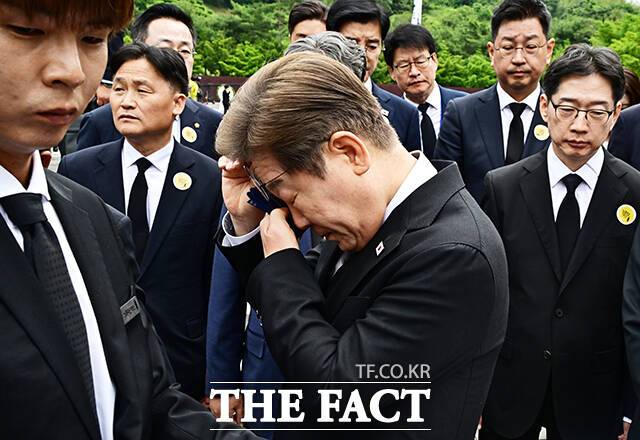 이재명 더불어민주당 대선 후보가 23일 오전 김해시 봉하마을 고 노무현 전 대통령 묘역을 찾아 참배를 마친 뒤 눈물을 닦고 있다./김해=배정한 기자